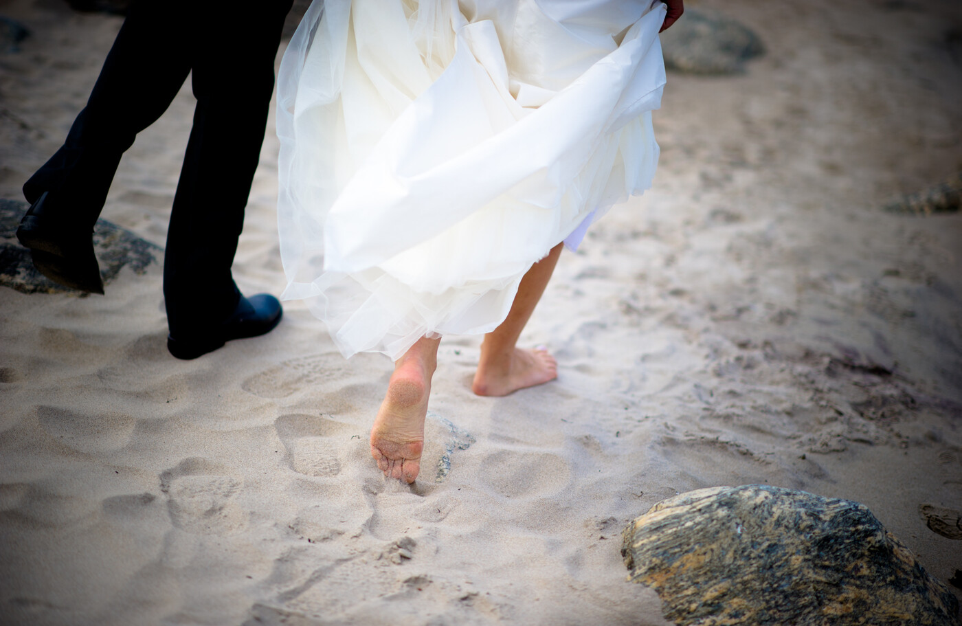 Bruden går barfota på stranden